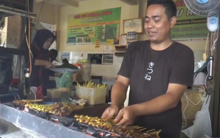 Warung Sate Suruh Bu Harkim di Jalan Jenderal Sudirman, Kota Salatiga, Jawa Tengah, menjadi pusat perhatian para pengunjung selama libur Natal dan Tahun Baru. Sate khas Suruh ini, terkenal dengan sate sapi dan ayam yang empuk, dihargai oleh para pecinta kuliner karena bumbu kacangnya yang khas dan aromatik. Berdiri sejak tahun 1980, warung sate ini mempertahankan reputasinya sebagai kuliner legendaris yang selalu ramai dikunjungi, tidak hanya oleh warga Salatiga, tetapi juga dari kota-kota lain seperti Boyolali, Semarang, bahkan Jakarta.
