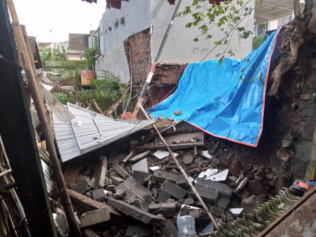 Talud dan tembok pembatas sepanjang 8 meter di kawasan Perumahan Graha Mutiara Gedangasri, Kelurahan Gedanganak, Ungaran Timur, Kabupaten Semarang, ambruk pada Senin (20/1/2025) malam, mengakibatkan kerusakan pada poskamling dan rumah warga. Peristiwa ini disaksikan oleh Sriwanti (46) dan Bayu Abilowo (32), warga setempat, yang mendengar suara gemuruh sebelum reruntuhan terjadi. Kejadian berlangsung saat hujan deras mengguyur wilayah tersebut, sekitar pukul 19.45 WIB.