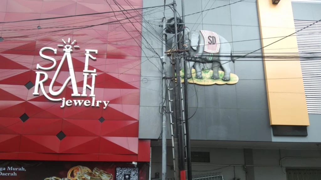 Jencien Restantio, pemilik Toko Mas Gajah di Jalan Jenderal Sudirman, Salatiga, mengeluhkan banyaknya jaringan kabel yang melintas di depan tokonya hingga menutupi logo usaha yang telah lama ia jalankan. Keluhan ini telah disampaikan ke pihak berwenang sejak Februari 2025, namun belum ada tindakan signifikan untuk mengatasinya.
