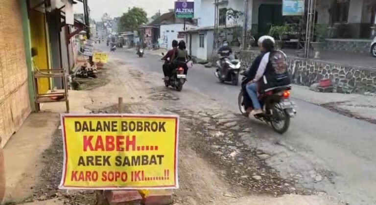 Jalan PTP Ngobo di Desa Wringin Putih, Bergas, Kabupaten Semarang rusak parah hingga membahayakan pengendara. Warga protes dengan spanduk karena sering terjadi kecelakaan akibat truk perusahaan. Senin (22/9/2025), DPU Semarang memastikan perbaikan jalan sepanjang 600 meter dengan beton segera dimulai agar aman dan tahan beban berat.