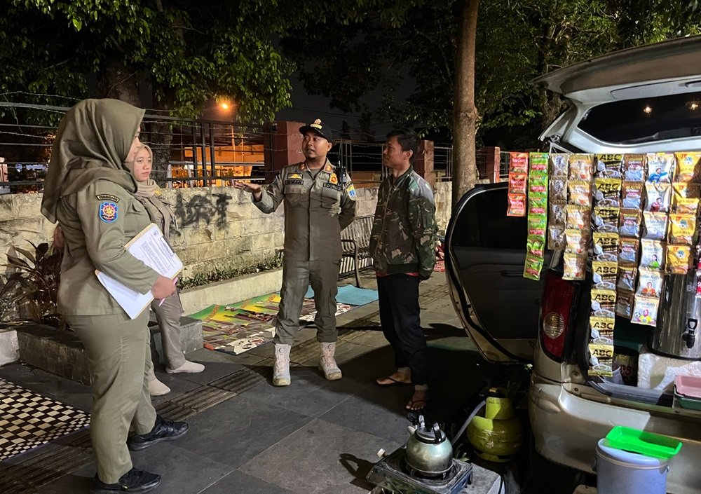 Satpol PP Kota Salatiga meningkatkan teguran kepada pedagang kopi di sepanjang Jalan Adi Sucipto dari Surat Peringatan (SP) 1 menjadi SP 2 pada Senin (26/10/2026) malam. Langkah ini menindaklanjuti aduan masyarakat terkait dugaan pengusiran warga sekaligus menegaskan fungsi trotoar sebagai fasilitas umum. Pemkot Salatiga juga menyiapkan kajian lokasi baru dan pengaturan waktu berjualan agar aktivitas PKL tetap berjalan tanpa mengganggu kenyamanan publik.